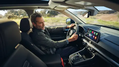 Model sitting inside the CR-V Hybrid car using Honda Sensing 360.