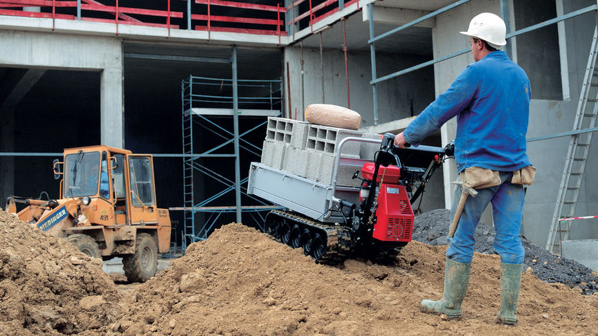 Honda petrol-fuelled power carrier being used by worker on a construction site to move heavy load