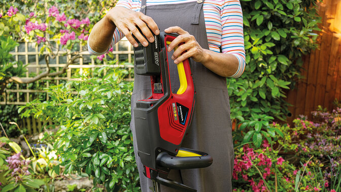 Woman inserting a battery into a leafblower