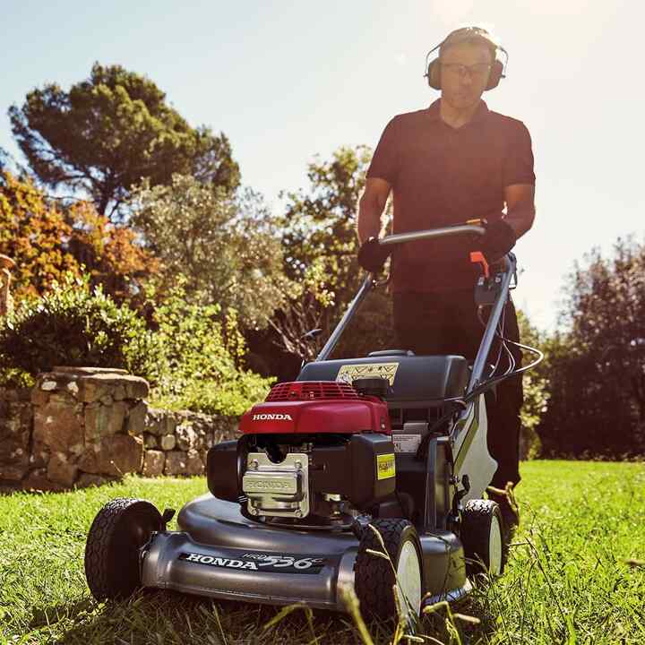 Man in garden location cutting grass with a Honda HRD mower.