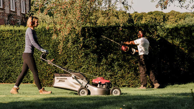Lady cutting the grass with a Honda HRH.