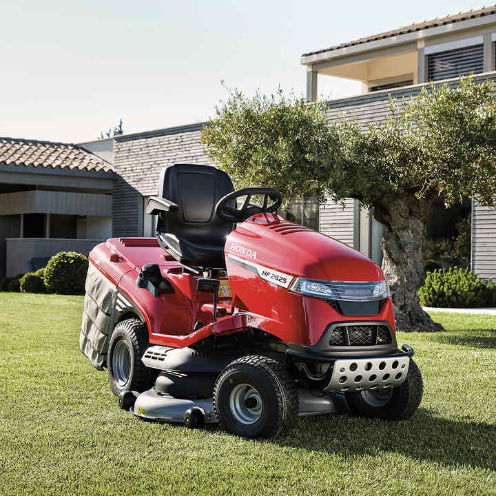 Front three-quarter view Honda tractor in a garden with house at the background
