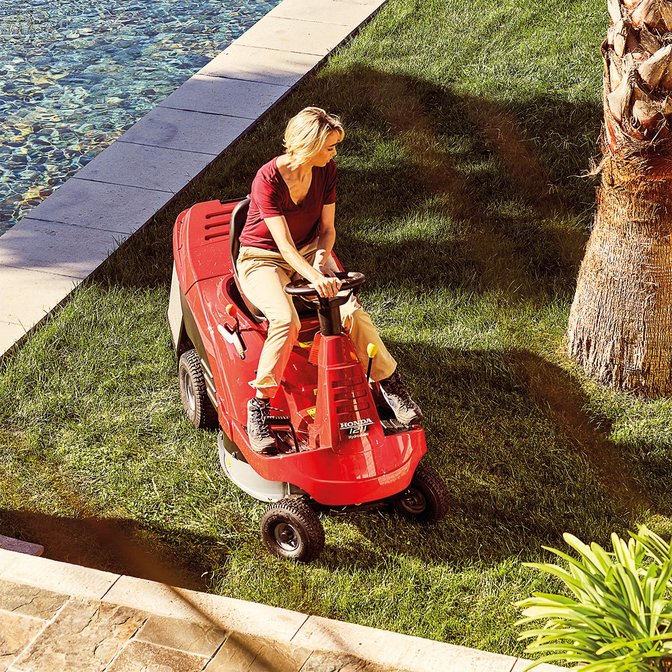Ride-on, front three-quarter, left facing, being used by model, garden location.