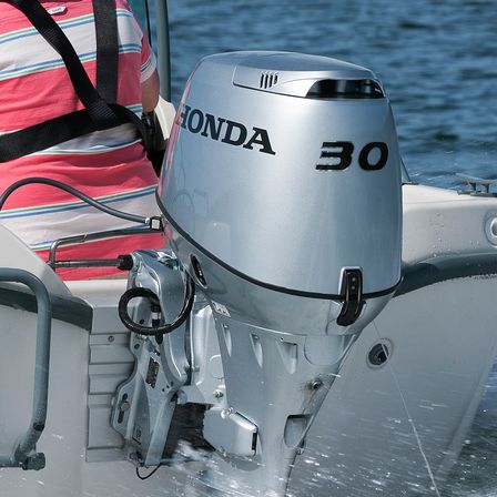 close up read view of a 30 horsepower honda marine engine attached on a boat