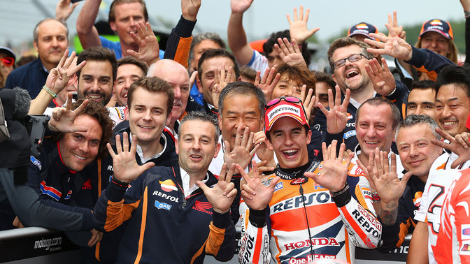 MotoGP racer celebrating a Honda win with crew.