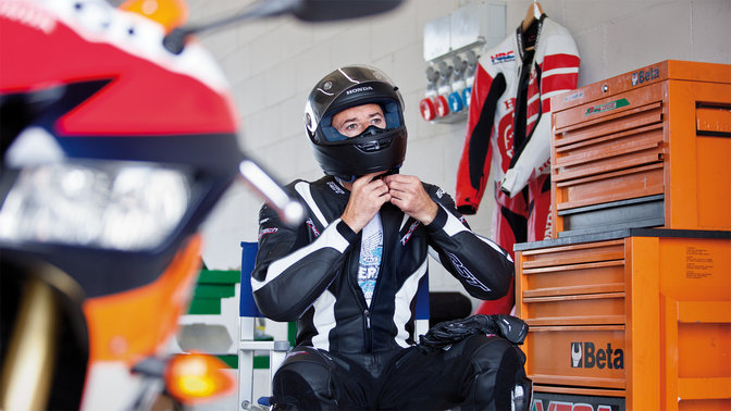 MotoGP rider in motorcycling gear and helmet.