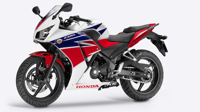 Side facing Honda motorcycle with red, white and blue livery.