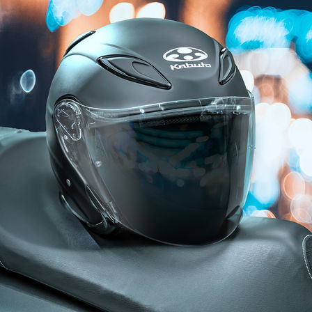 Honda Kabuto helmet, Avand II - Flat Black, sitting on the saddle of a motorcycle
