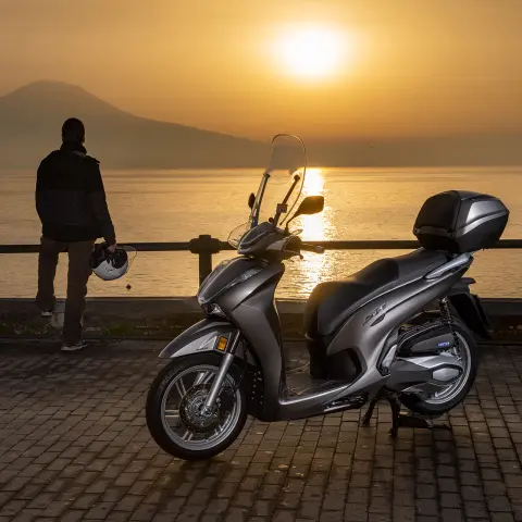 Honda SH350 with coastal horizon at sunset and rider