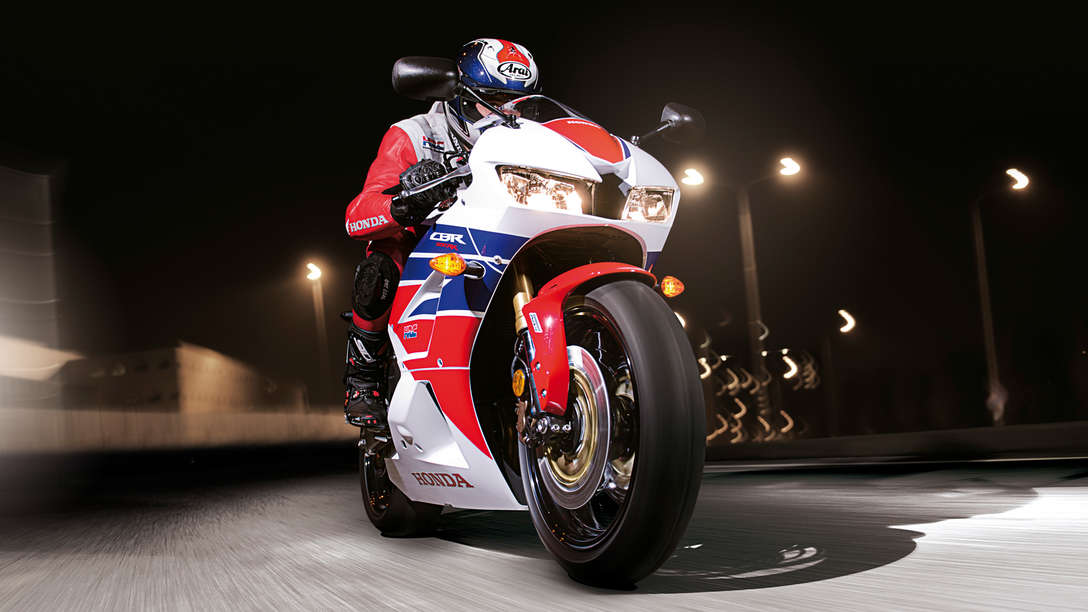 Honda CBR600RR motorbike front-threequarter view with rider. Right-facing (Road location).