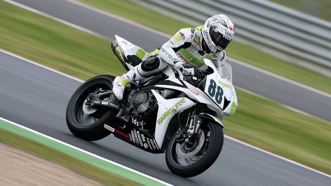 Rear 3-quarter view of CBR600RR. Tilted slightly, with rider.