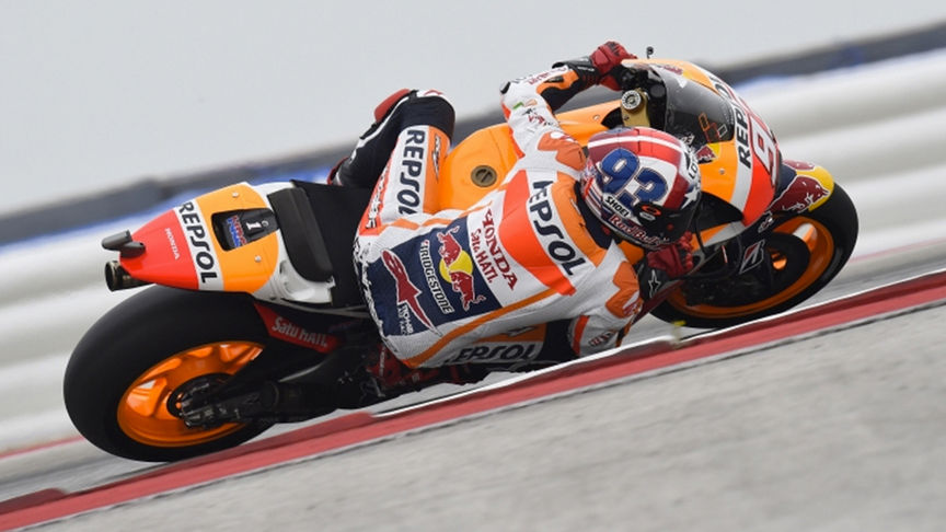 orange racing bike on track with rider in orange outfit 