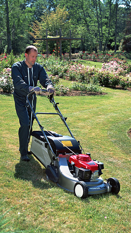 Lawnmower, front three-quarter, right facing, being used by model, garden location.