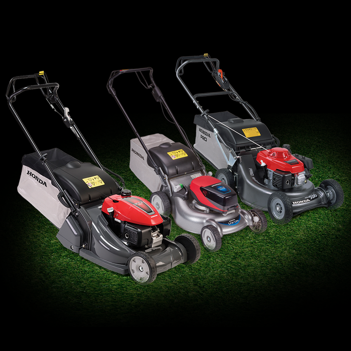HRX lawnmower, izy-ON lawnmower, and IZY lawnmower on grass in a dark background