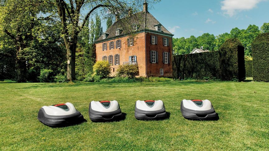 front view of team of honda miimo robotic lawnmowers on a lawn in the garden