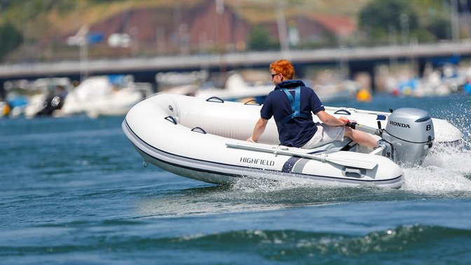 Boat with Honda engine, being used by model, coastal location.