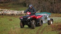 Side view of Fourtrax 420, being used by model, field location.