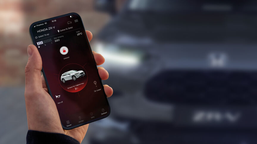 Child holding tablet strapped into back seat of the car