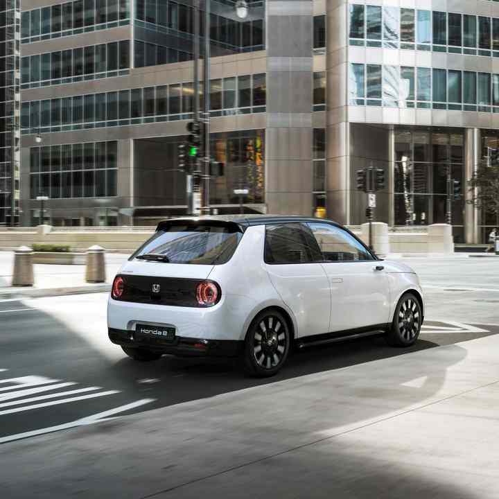 Honda-e in a steet with buildings in the background