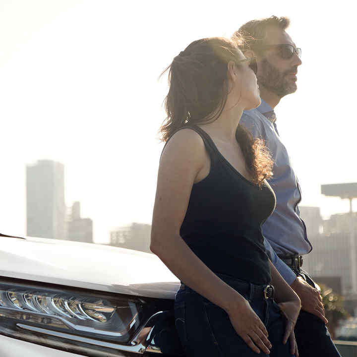 Honda Car passengers leaning on the bonnet