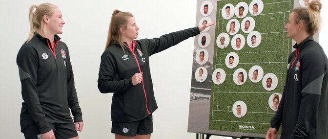 Three members of Red Roses team next to rugby pitch mock up.