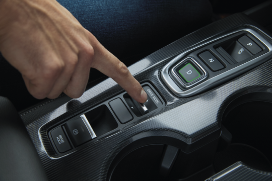 a hand about to push the drive mode button inside a Honda car