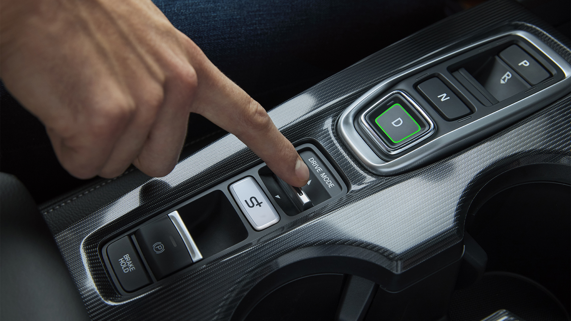 Close up on a person switching drive modes inside the Civic Hybrid.