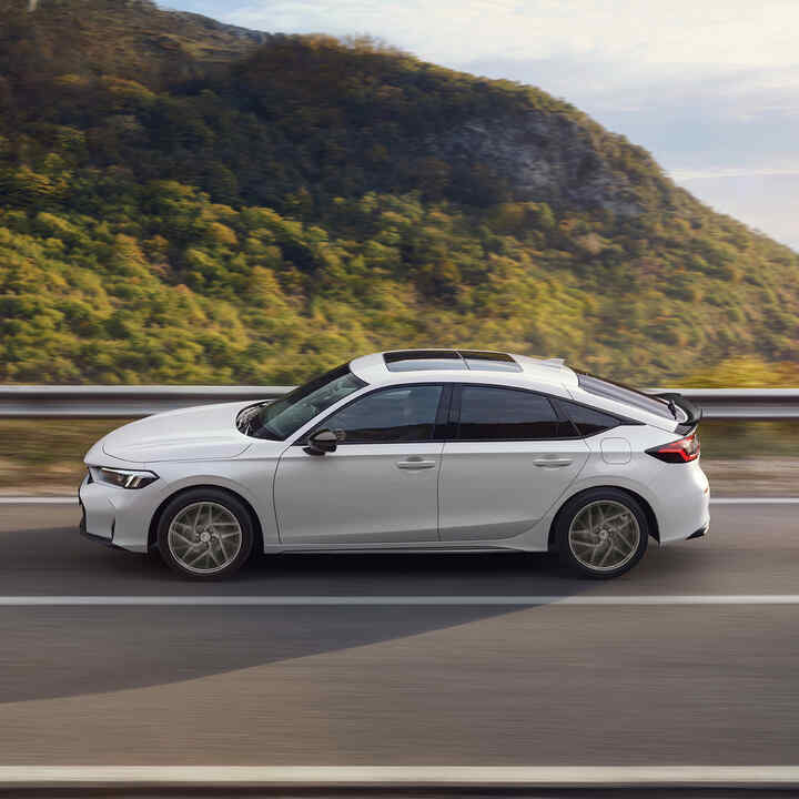 Honda Civic Hybrid in motion on a highway, with scenic view.