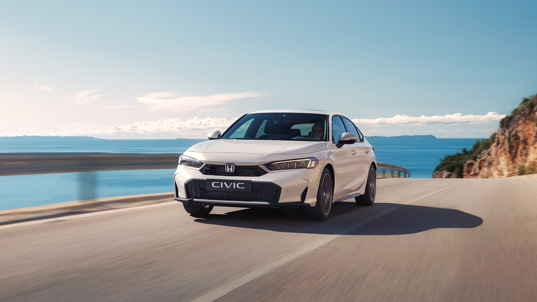 Honda Civic Hybrid in motion on a highway.