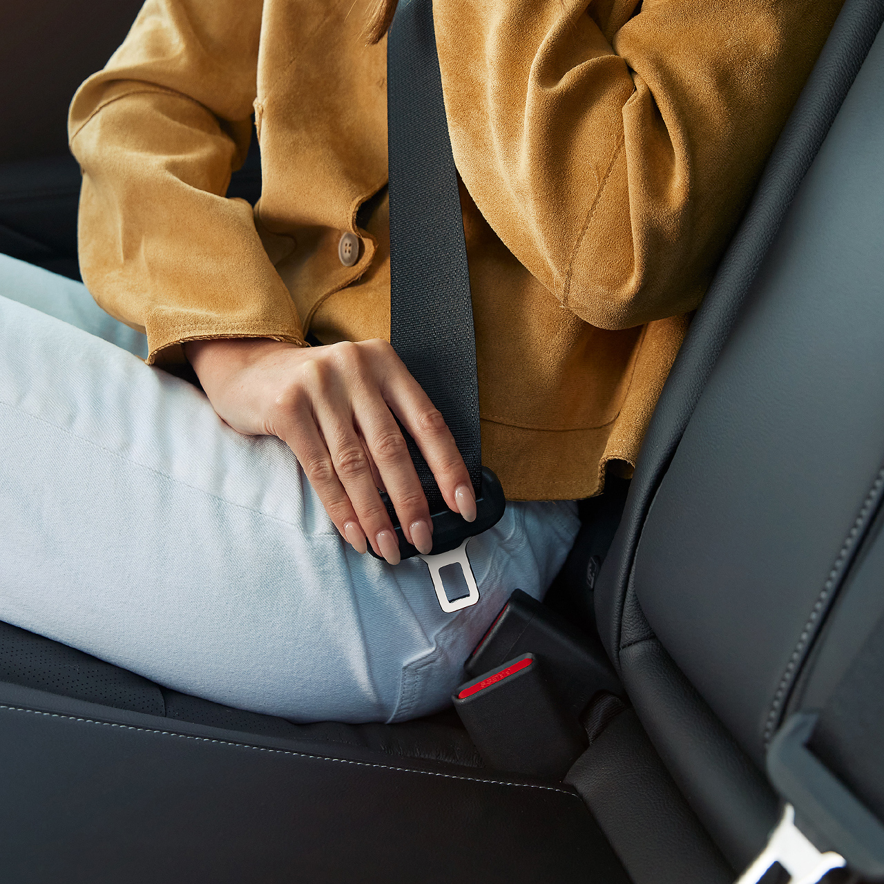 A person fastening their seat belt inside the Honda Civic Hybrid.