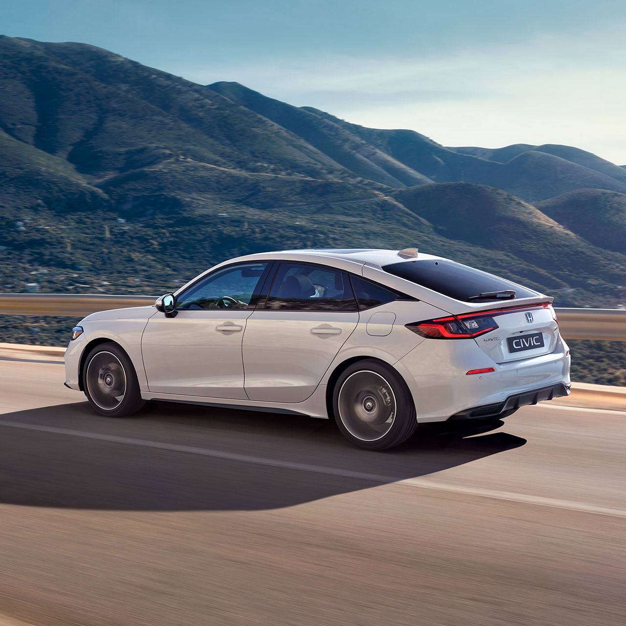 Honda Civic Hybrid in motion on a highway, in a scenic view.