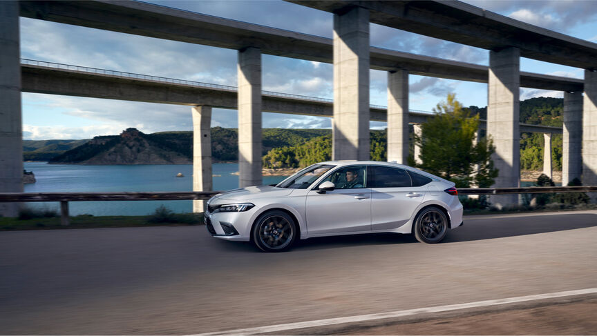 Side view of the Honda Civic e:HEV parked infront of the sea. 