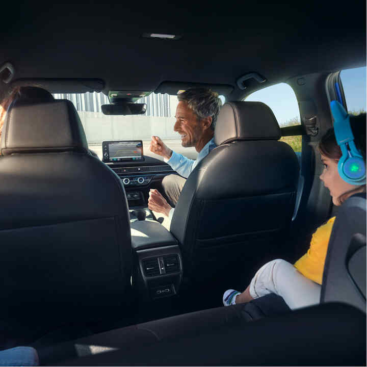 View from the back seats of a family sitting inside the car. 