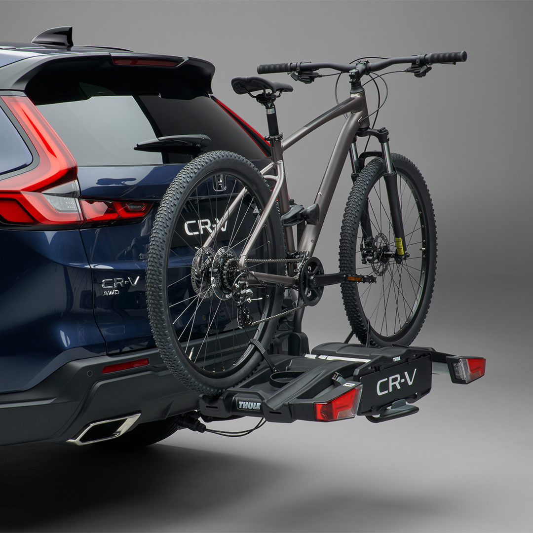 Rear three-quarter facing Honda CR-V Hybrid with bicycle carrier.