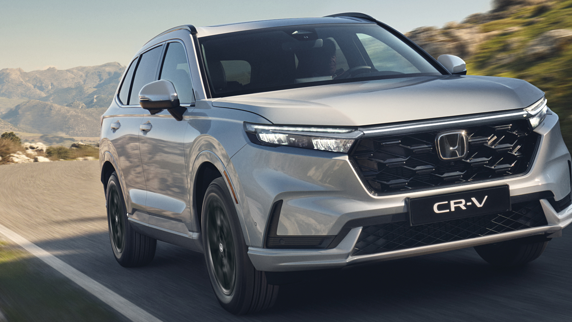 Front three-quarter facing Honda CR-V Hybrid in mountain location.