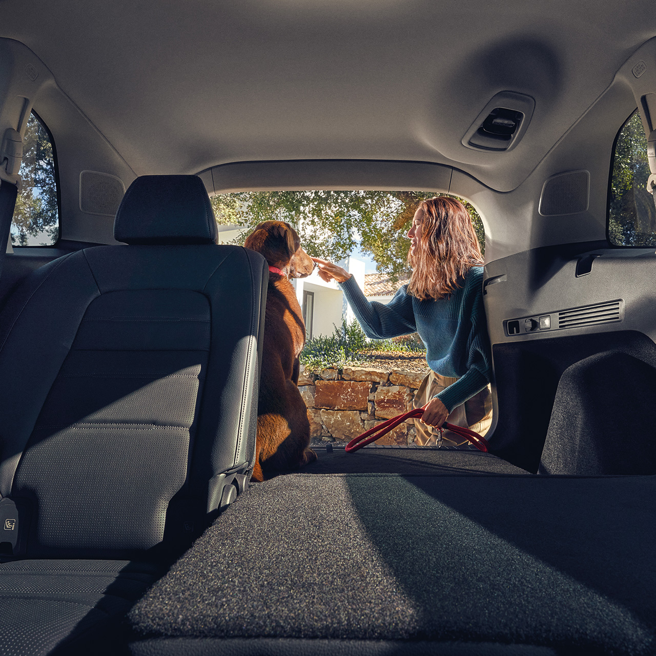 CR-V Hybrid SUVrear seat reclined with female and dog at the open boot.