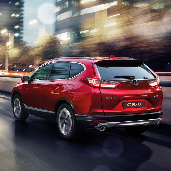 Rear three-quarter facing Honda CR-V, city location.