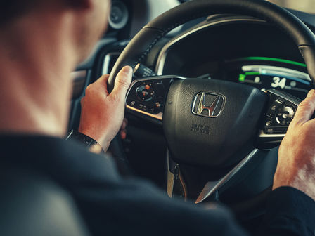Honda CR-V Hybrid close up of model in car with steering wheel.