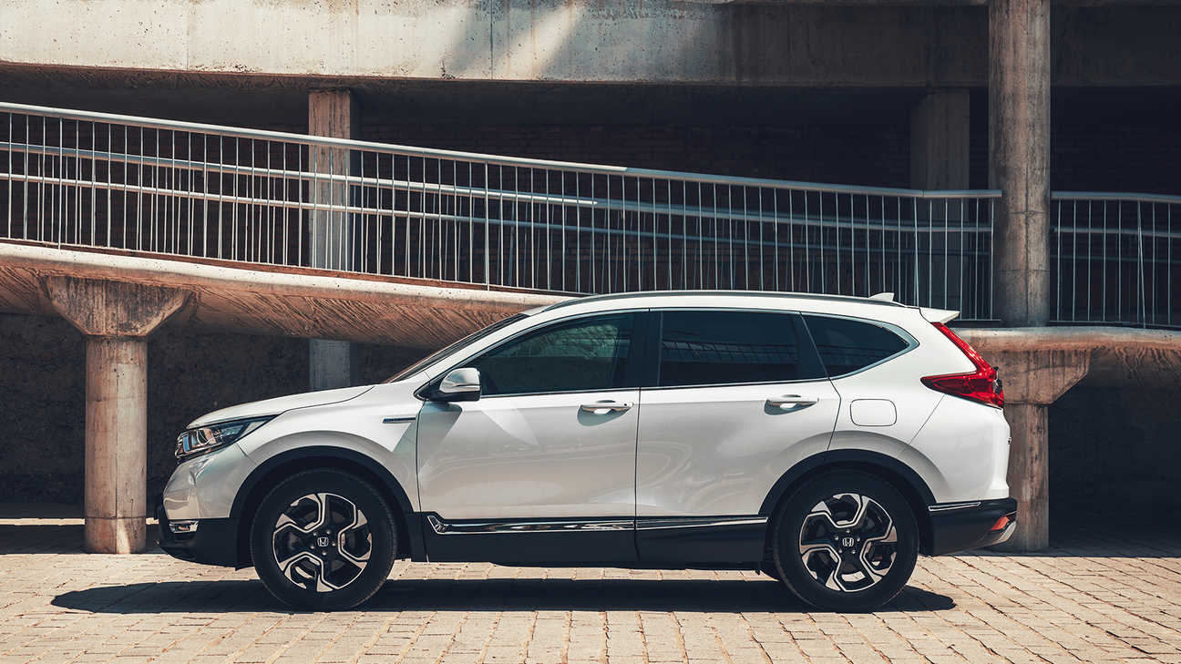 Side facing view of Honda CR-V Hybrid car in street location.