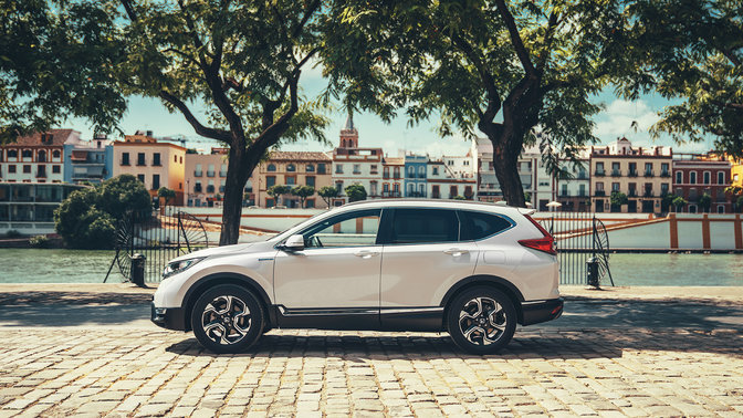 Side facing Honda CR-V Hybrid car in street location.
