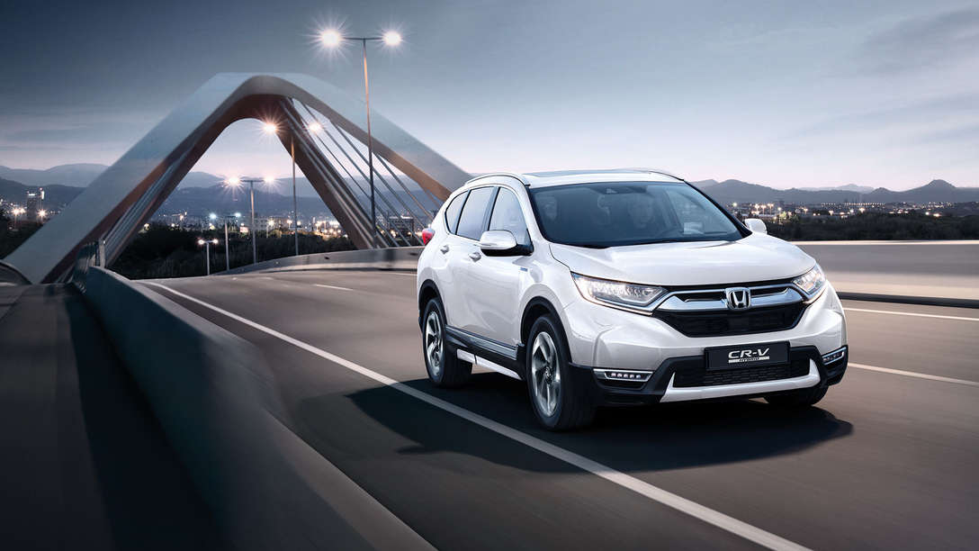 Front three-quarter facing Honda CR-V Hybrid car in street location.