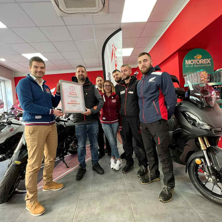 Honda motorcycle dealers celebrating their recognition award.
