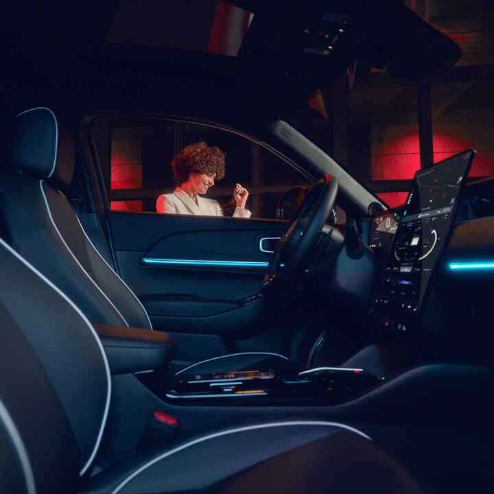 Illuminated interior on the Honda e:Ny1 at night with model outside the window.