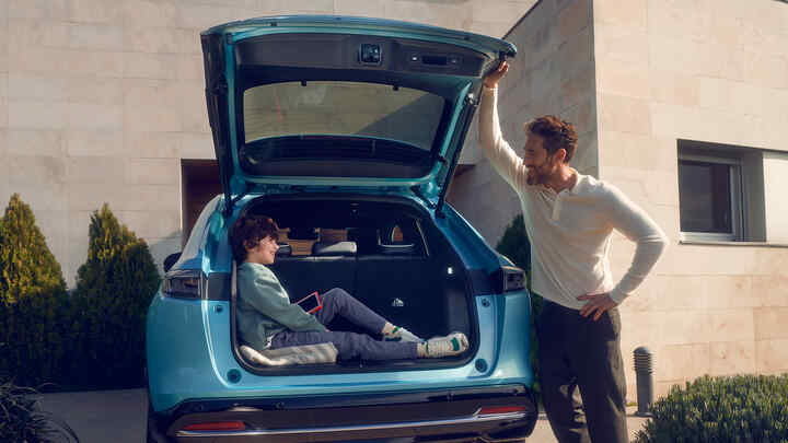 Father speaking to child sitting in the Boot of the Honda e:Ny1.