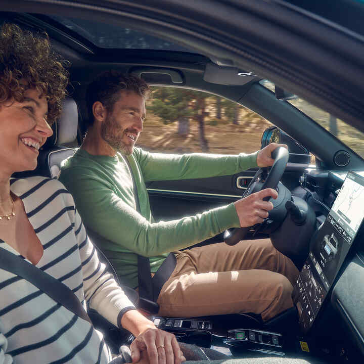 Couple driving the Honda e:Ny1 in the country. 