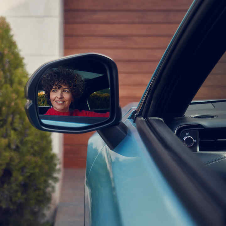 Females reflection in the door mirror on the Honda e:Ny1.