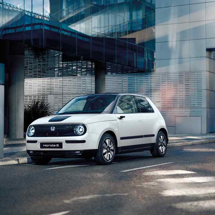 Honda e in the street with buildings at the background