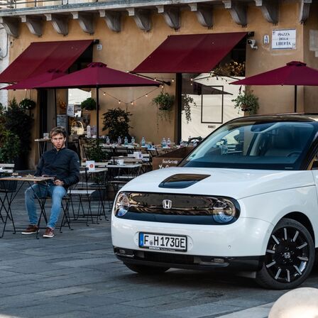Piere Gasely sitting in a cafe with front of Honda e