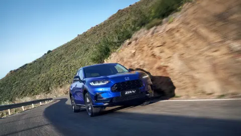 ZR-V Hybrid car driving on road in mountain location.