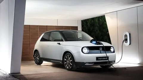 Honda e parked and charging in a private residence.
